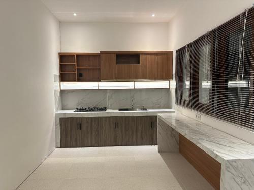 a kitchen with wooden cabinets and a counter top at Casa Luma Canggu in Canggu