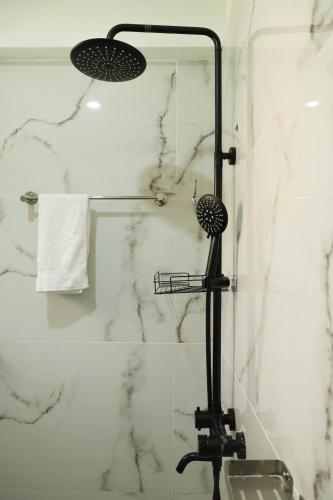 a shower in a bathroom with a black shower head at Casa-Koker Residences in Kisumu