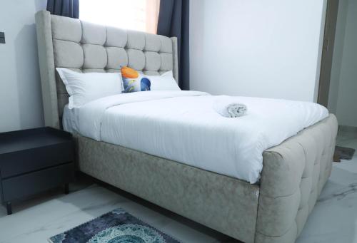 a bedroom with a large bed with a white mattress at Casa-Koker Residences in Kisumu