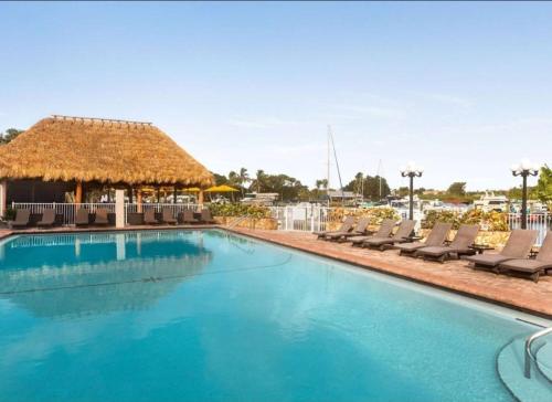 a large swimming pool with chairs and a gazebo at Sunset Cove - Water View in Sarasota