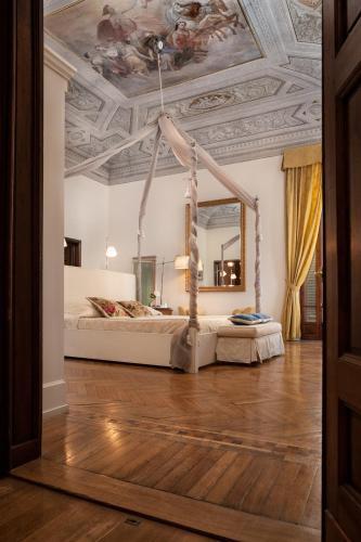 a bedroom with a bed with a ceiling with a mirror at Hotel Executive in Florence