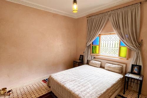 a bedroom with a bed and a window at Dar Dahlia Atlas Valley in Oulad Akkou