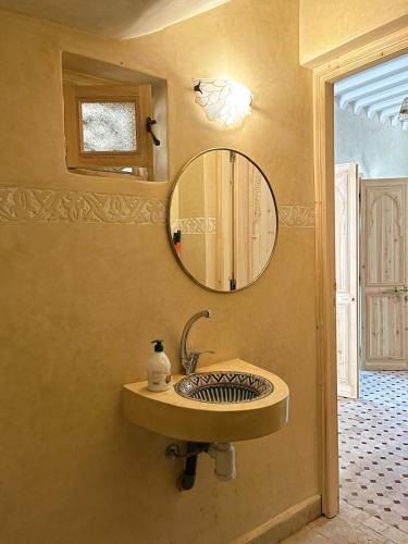 a bathroom with a sink and a mirror on the wall at Dar Dahlia Atlas Valley in Oulad Akkou