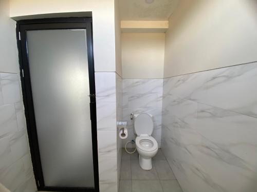 a bathroom with a white toilet in a stall at Angkasa Sunrise Villa in Saba