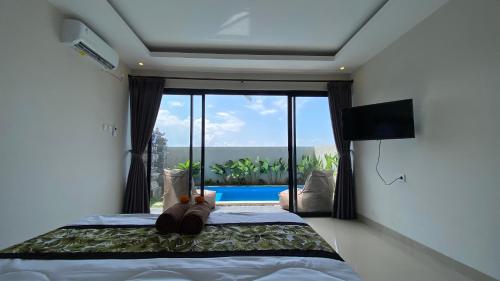 a bedroom with a bed with a view of a pool at Angkasa Sunrise Villa in Saba