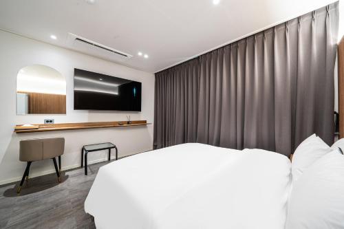 a hotel room with a bed and a desk at Brown Dot Hotel Hot Spring Yuseong in Daejeon