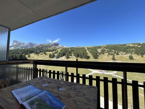 a table on a balcony with a view of the mountains at Studio 4 pers à SuperDevoluy avec wifi et terrasse - FR-1-525-297 in Superdevoluy