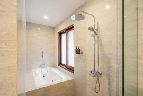 a bathroom with a shower and a tub and a sink at Modern 5BR Luxury Villa with Pool & Rooftop - 100m from Sanur Beach in Sanur