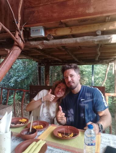 a man and a woman sitting at a table eating food at Atha Tree House in Habarana