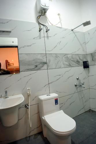 a bathroom with a toilet and a sink at Dune Homestay in Alleppey