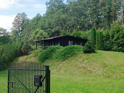 a house on top of a hill with a fence at Domek nad Trojanką koło Olsztyna Blisko jeziora in Wrzesina