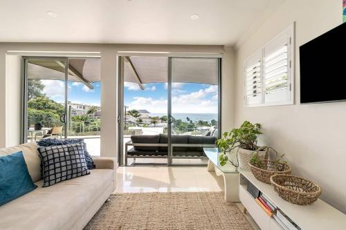 テリガルにあるAmelie - Luxury Beach View Condo Minutes To Beachのソファがあり海が見えるリビングルーム