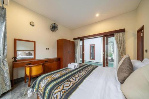 a bedroom with a bed and a desk and a mirror at Modern 5BR Luxury Villa with Pool & Rooftop - 100m from Sanur Beach in Sanur
