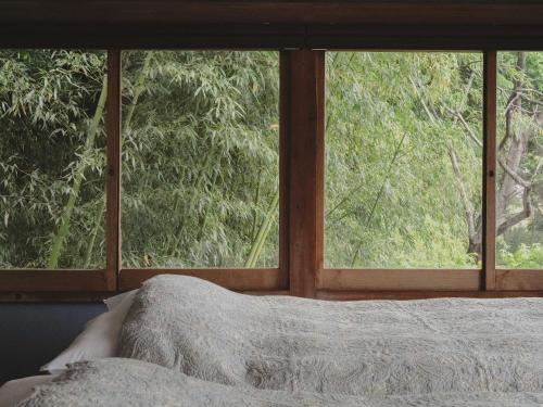 a bedroom with a window looking out at a tree at THE LAKE Kawaguchiko-kurashi in Fujikawaguchiko