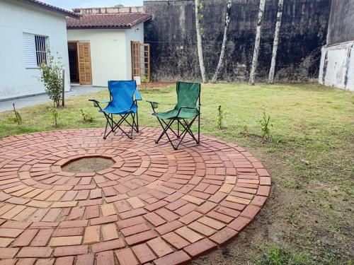 two chairs sitting on a circular brick patio at Suíte no Jardim à Beira-Mar in Peruíbe