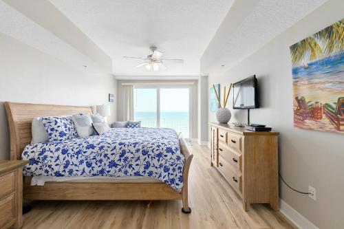a bedroom with a bed and a television and a window at Beachfront 3br Condo With Stunning Views Daytona in Daytona Beach Shores