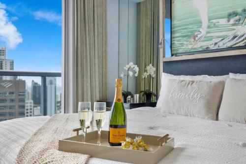 a bottle of champagne and two glasses on a bed at W hotel High end ocean view 2 bedroom at icon brickell in Miami