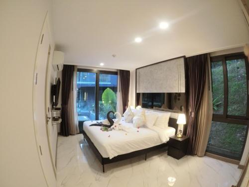 Un dormitorio con una cama blanca con una ventana grande. en B407-High Floor Pool View 1 Br At Ao Nang Beach, en Ao Nang Beach