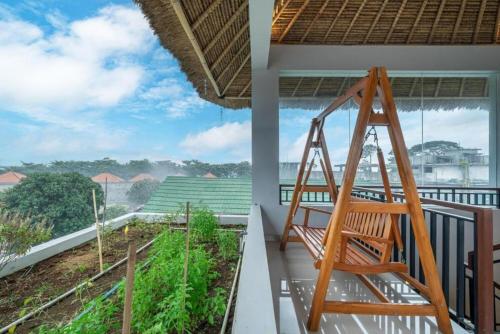a wooden swing on the balcony of a house at Modern 5BR Luxury Villa with Pool & Rooftop - 100m from Sanur Beach in Sanur