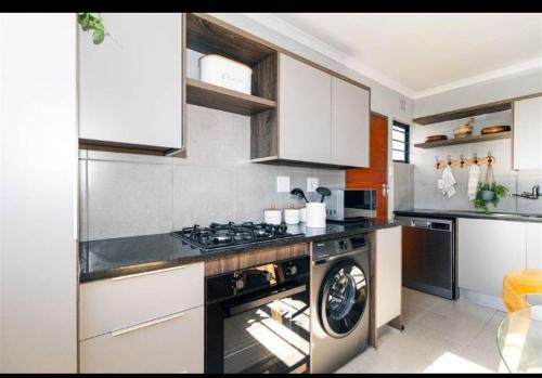 a kitchen with a stove and a washing machine at Mortimer in Germiston
