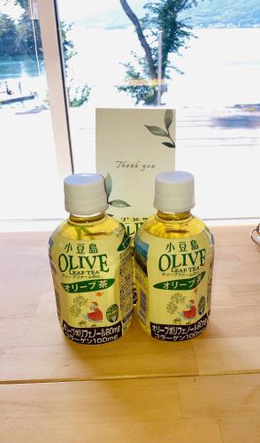 two bottles of olive oil sitting on a table at 藤田別荘 in Shodoshima