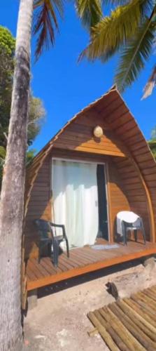 a small house on the beach with a palm tree at Peixe na Patioba in Porto Seguro