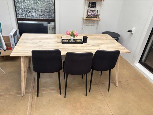 a wooden table with four chairs in a room at One bedroom with breakfast in Auckland