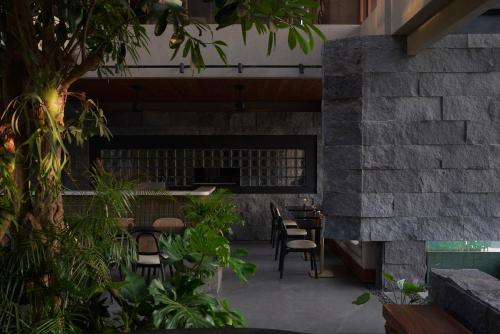 een patio met tafels, stoelen en planten bij The Akasha Canggu Hotel in Canggu