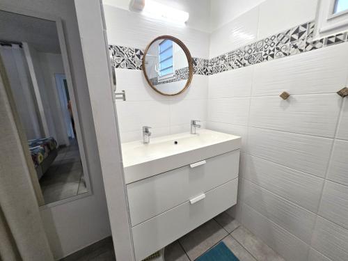 a white bathroom with a sink and a mirror at Villa Carpe Diem - Piscine - 9 pers - 4 Chambres in Les Trois-Îlets