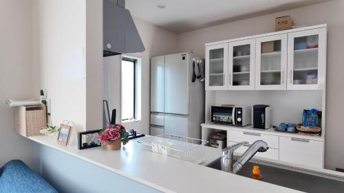 a kitchen with white cabinets and a white counter top at First sight hut house in Tokyo