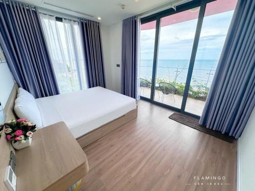 a bedroom with a bed and a view of the ocean at Flamingo Ibiza Hải Tiến, Căn 2 phòng ngủ view trực diện biển tiêu chuẩn 4NL 2TE in Thanh Hóa