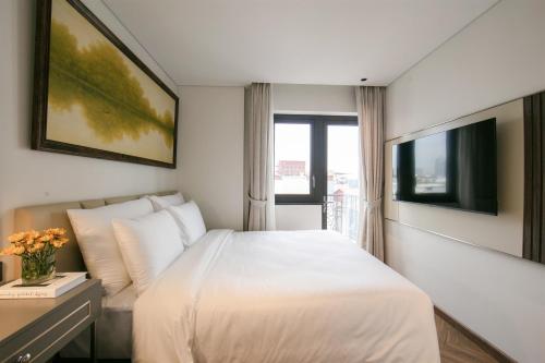 a hotel room with a bed and a tv at Léman Old Quarter in Hanoi