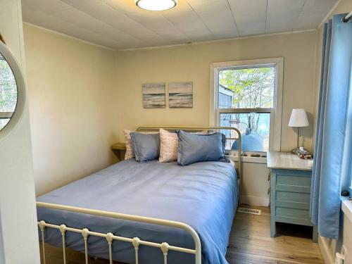 ein Schlafzimmer mit Bett, Schreibtisch und Fenster in der Unterkunft Peaceful Lily Pad Cottage In Hubbards in Hubbards