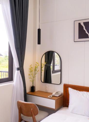 a bedroom with a bed and a mirror and a chair at Soha Hotel Cần Thơ in Cái Răng