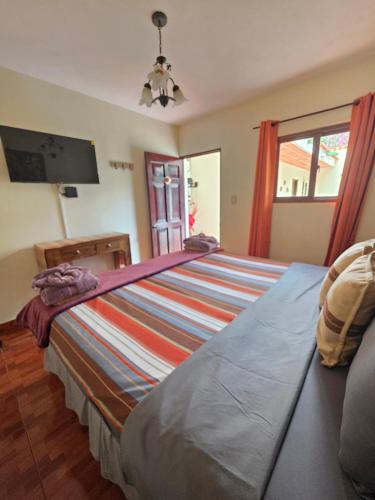 a bedroom with a large bed and a television at Casa Nazareno in Antigua Guatemala