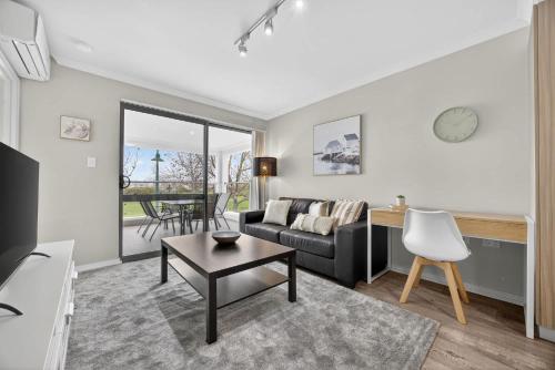 a living room with a couch and a table at Modern 2BR Apartment in the Heart of Rockingham Close to Beach Shops & Naval Base in Rockingham