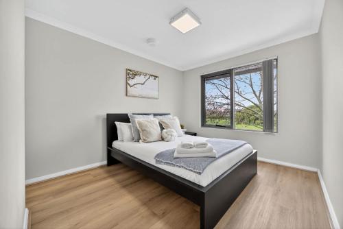 a bedroom with a bed and a window at Modern 2BR Apartment in the Heart of Rockingham Close to Beach Shops & Naval Base in Rockingham
