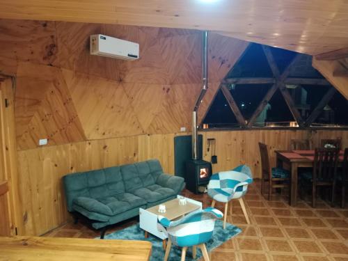 a living room with a green couch and a table at Domos Maran Lican Ray in Licán Ray