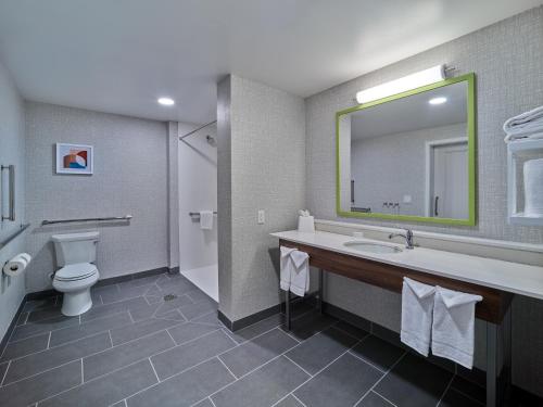 a bathroom with a sink and a toilet and a mirror at Hampton Inn & Suites Omaha Un Medical Center Area in Omaha