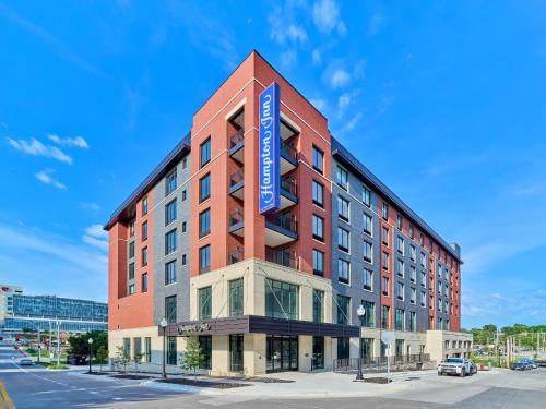 a large red building with a blue sign on it at Hampton Inn & Suites Omaha Un Medical Center Area in Omaha