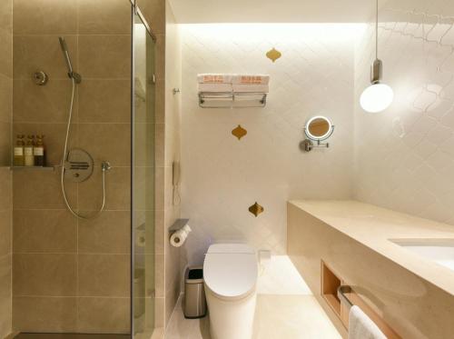 un bagno con wc e doccia in vetro di Beijing Guomao Business District Sihui Orange Crystal Hotel a Pechino