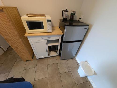 a small kitchen with a microwave and a refrigerator at Gordie's Inn & Suites in Alert Bay