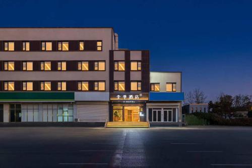 a large building with its lights on at night at JI Hotel Beijing Huilongguan West Street全季北京回龙观西大街酒店 in Beijing