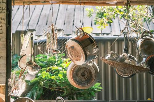 a bunch of pots and pans are hanging from a window at Cú Trên Cây Homestay in Xuan An