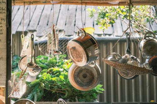 a bunch of pots and pans hanging from a window at Cú Trên Cây Homestay in Xuan An