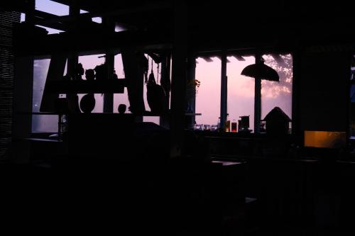a silhouette of a window with a sunset in the background at Cú Trên Cây Homestay in Xuan An
