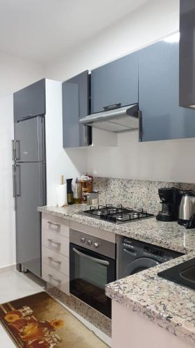 a kitchen with stainless steel appliances and blue cabinets at Wohnung Blick am Meer in Agadir