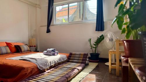 Un dormitorio con una cama y un sofá con un animal de peluche. en Baan PadSeeEw - Rooftop Riverview 2nd floor, en Thonhuri