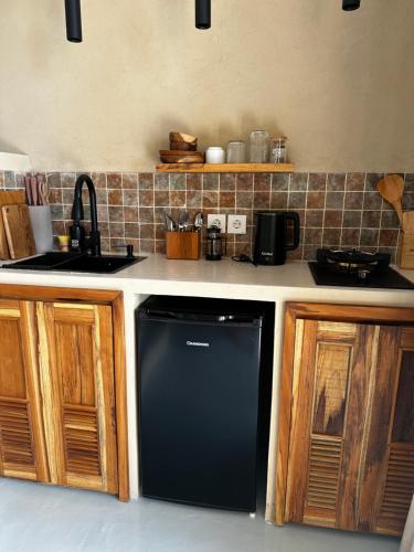 a kitchen with a black dishwasher in a kitchen at Jepun Hill Studios & Amed Jepun Divers in Amed