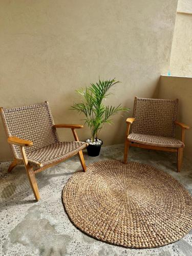 two wicker chairs and a rug in a room at Jepun Hill Studios & Amed Jepun Divers in Amed